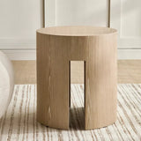 Wooden side table with a minimalist design on a striped rug.