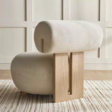 Modern chair with cylindrical backrest and wooden legs in a room with light-colored walls and floor.